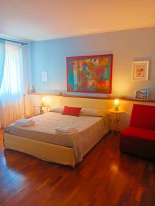 a bedroom with a large bed and a red chair at La quercia di Massena in Lauria Inferiore