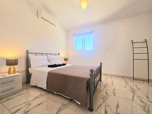 1 dormitorio con cama y ventana en 2BD Garden Apartment, en Pafos