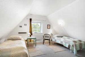 um quarto com 2 camas, uma mesa e uma janela em Præstøgaard em Praesto