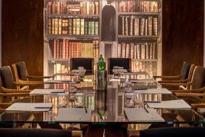 una mesa larga en una biblioteca con libros en Hotel Federico II Central Palace, en Palermo