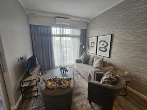 ein Wohnzimmer mit einer Couch und zwei Sesseln in der Unterkunft Capital Trilogy Apartments in Pretoria + 4 Fotos