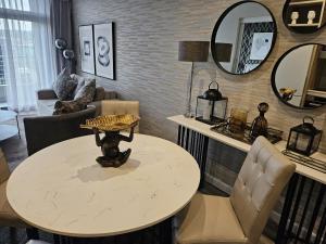 ein Wohnzimmer mit Tisch, Stühlen und Spiegeln in der Unterkunft Capital Trilogy Apartments in Pretoria