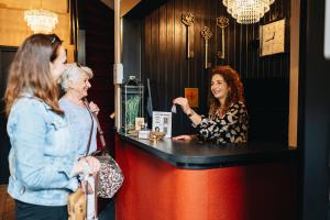dwie kobiety stojące przy ladzie w barze w obiekcie Hotel - B&B Renesse w mieście Renesse