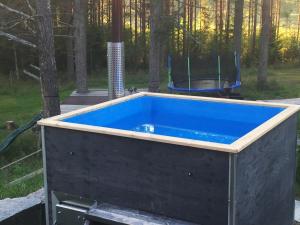 a hot tub in the middle of a yard at Large Family Apartment UNELMA - Tahko, Palju, BBQ, Sauna, WiFI, PetsOK, Budget, Wanha Koulu Tahkovuori in Reittiö