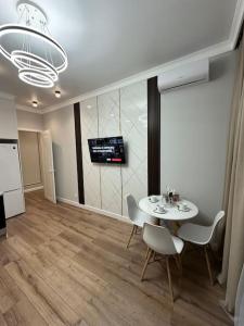 a dining room with a table and chairs and a television at Апартаменты в ЖК Sezim Qala Senim-3 (5 этаж) in Astana +2 photos