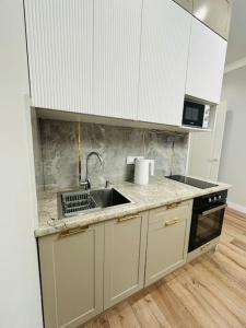a kitchen with a sink and a stove at Апартаменты в ЖК Sezim Qala Senim-3 (5 этаж) in Astana