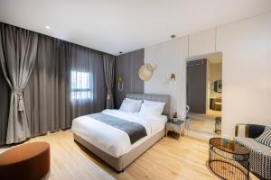 a bedroom with a bed and a living room at Allenbeach TLV- Adults only - WE HAVE SHELTER in Tel Aviv