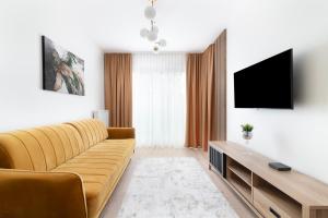 een woonkamer met een bank en een flatscreen-tv bij EASY RENT- North, Free Parking, 24h Check-in in Lublin