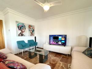 uma sala de estar com um sofá e uma televisão numa mesa em La Carihuela a 150 metros de la playa con espectaculares vistas em Torremolinos