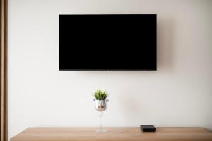 een televisie aan een muur met een vaas op een tafel bij EASY RENT- North, Free Parking, 24h Check-in in Lublin