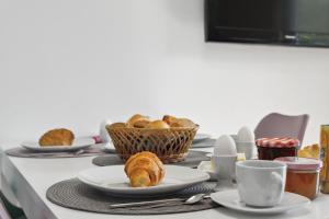 a table with plates of pastries and cups on it at Wellness & Komfortferienwohnung Strandliebe mit Sauna, Terrasse, Garten & Balkon, bei Laboe in Lutterbek