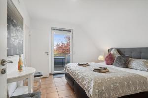 ein Schlafzimmer mit einem Bett und ein Bad mit einem Fenster in der Unterkunft Wellness & Komfortferienwohnung Strandliebe mit Sauna, Terrasse, Garten & Balkon, bei Laboe in Lutterbek