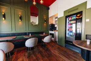 a restaurant with a bar with chairs and a refrigerator at Hotel - B&B Renesse in Renesse