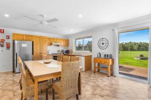 Una cocina y un comedor con mesa y sillas. en Madigan Cottages - The Homestead, en Lovedale