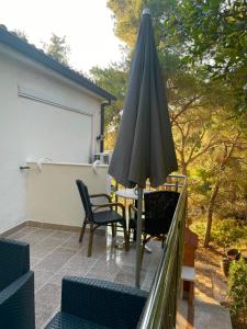 a patio with an umbrella and a table and chairs at Villa Terra Nostra Hvar in Hvar