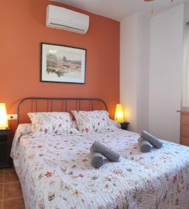 a bedroom with a bed with two pillows on it at Homes of Spain, Casa Duplex Playas del Sur, 400m del mar , WIFI in Playas de Vera