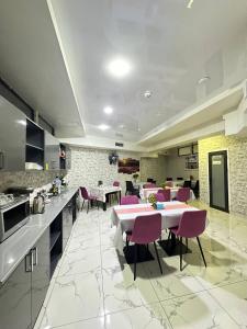 eine große Küche mit rosa Stühlen und einem Tisch in der Unterkunft Apple Hotel 小苹果酒店 FREE Airport Service in Taschkent