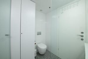 uma casa de banho branca com um WC e um chuveiro em סיסייד אילת חדר עם נוף לים - Seaside Eilat Room With Sea View em Eilat