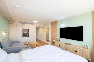 Schlafzimmer mit einem Bett und einem Flachbild-TV in der Unterkunft סיסייד אילת חדר עם נוף לים - Seaside Eilat Room With Sea View in Eilat