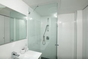 a white bathroom with a shower and a sink at Sea Side-Family Heaven Vacation Amazing Pool Eilat in Eilat