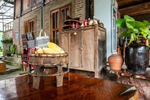 a basket of bananas sitting on a wooden table at Lim's house in Mai Chau