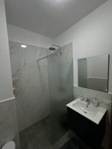 W łazience znajduje się umywalka oraz prysznic z lustrem. w obiekcie Laert's Appartement w Tiranie
