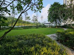a park with green grass and a bridge in the background at Meridin Medini, Iskandar Puteri, Johor in Nusajaya