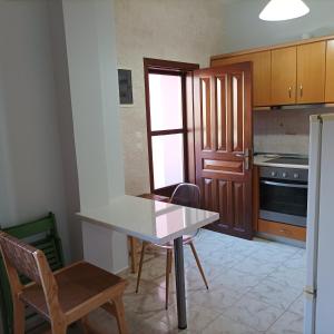 a kitchen with a white table and chairs in it at Pedi Breeze in Symi