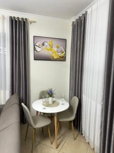 salon z białym stołem i krzesłami w obiekcie Laert's Appartement w Tiranie