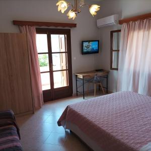 Schlafzimmer mit einem Bett, einem Tisch und einem Fenster in der Unterkunft Pedi Breeze in Symi
