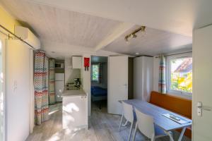 eine kleine Küche und ein Esszimmer mit einem blauen Tisch in der Unterkunft Eurocamp Spreewaldtor in Groß Leuthen