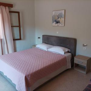 1 dormitorio con 1 cama con edredón rosa en Pedi Breeze, en Symi