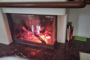 a fire in a fireplace in a room at Wildflowers House - JApartments in Genoa