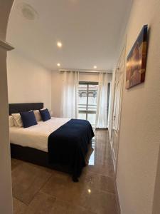 a bedroom with a bed with blue pillows and a window at REGIDOR Cartagena in Cartagena +36 photos