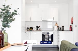 cocina blanca con armarios blancos y fogones en St Mary's Retreat By Your Lettings Short Lets & Serviced Accommodation Peterborough With Free WiFi,Parking And More, en Huntingdon