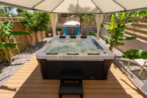 Modular Bungalows With Heated Pool Artemis Greece في أرتيميدا: حوض استحمام ساخن في وسط حديقة