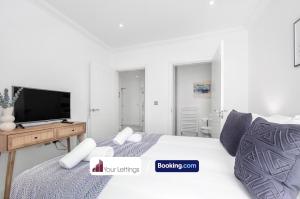 Habitación blanca con cama y TV en St Mary's Retreat By Your Lettings Short Lets & Serviced Accommodation Peterborough With Free WiFi,Parking And More, en Huntingdon