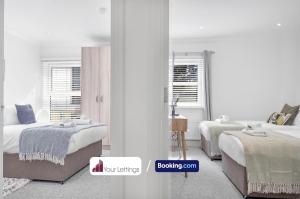 1 dormitorio blanco con 2 camas y ventana en St Mary's Retreat By Your Lettings Short Lets & Serviced Accommodation Peterborough With Free WiFi,Parking And More, en Huntingdon
