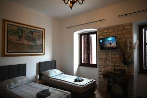 sypialnia z dwoma łóżkami i telewizorem na ścianie w obiekcie Ivana Rooms w Puli