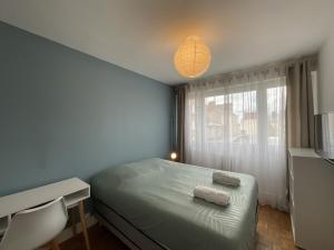 Un dormitorio con una cama, un escritorio y una lámpara. en L'Éperon - Centre - Parking - 6 pers, en Le Mans