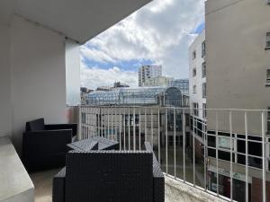 Un balcón con sillas y vista a una ciudad. en L'Éperon - Centre - Parking - 6 pers, en Le Mans