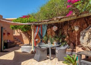 eine Terrasse mit einem Tisch, Stühlen und Blumen in der Unterkunft Casa de la Roca - A Beautiful 2 Bed/2 Bath Detached Villa in Almería