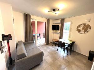 salon z kanapą i stołem w obiekcie Résidence hôtelière les hameaux de saint cyprien 25 M2 w mieście Lecci