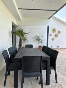 einen schwarzen Esstisch mit schwarzen Stühlen in der Unterkunft Olivia Estate South Corfu in Bastátika
