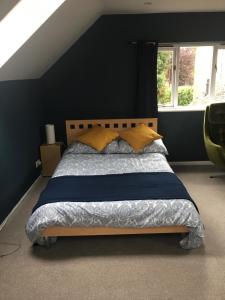um quarto com uma cama com uma parede preta em Oxfordshire Village Apartment em Rotherfield Peppard