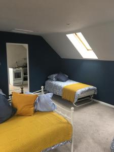 um quarto com 2 camas e uma clarabóia em Oxfordshire Village Apartment em Rotherfield Peppard