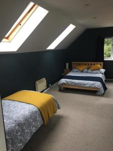 um quarto com 2 camas e uma clarabóia em Oxfordshire Village Apartment em Rotherfield Peppard