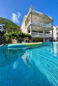 una piscina con tabla de planchar frente a un edificio en Family House with pool & sea view, en Bijela