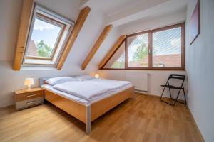 a bedroom with a bed and two windows at Apartment Riviera 504-4 Lipno Home in Český Krumlov
