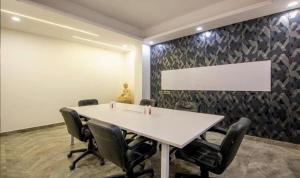 uma sala de conferências com uma mesa branca e cadeiras em The Embassy Inn em Noida